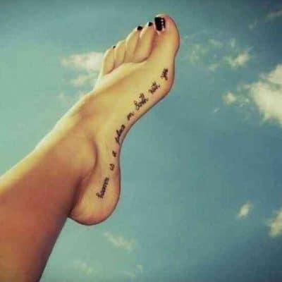 woman's text foot tattoo written on edge of foot with sky background 