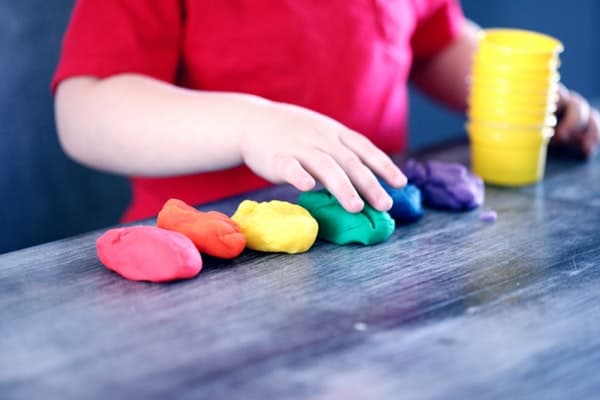 child and line of rainbow clay