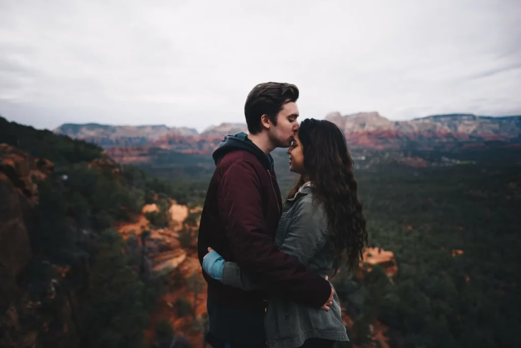 A couple hugging each other with a scenic backdrop