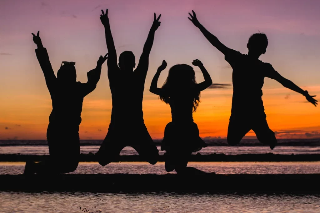 Photo of kids jumping with a sunset backdrop[ 